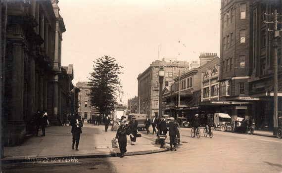 This black-and-white card shows a city street with pedestrians, bicycles, motor vehicles and commercial buildings; on the card is printed “Hunter St Newcastle”, “WESTMINSTER HOTEL”, “CAFE” and “THE COMMERCIAL BANK OF AUST”.