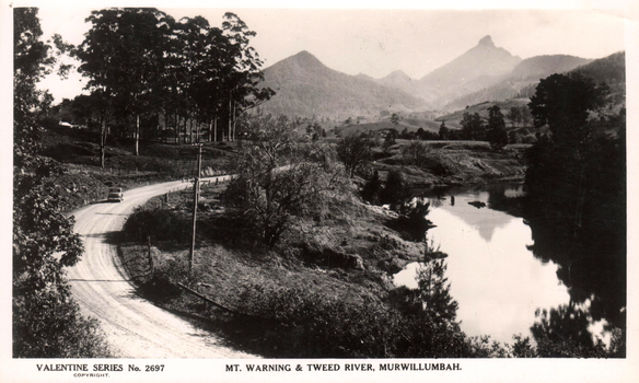 This black-and-white card shows a winding road beside the Tweed River with Mount Warning in the background: On the card is printed “VALENTINE SERIES No. 2697 COPYRIGHT. MT. WARNING & TWEED RIVER, MURWILLUMBAH.”
