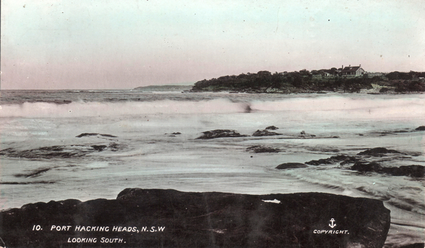 This coloured card shows a rocky ocean shoreline with a distant headland: On the card is printed “10. PORT HACKING HEADS, N.S.W LOOKING SOUTH. COPYRIGHT.”