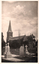This black-and-white card shows a church with a tall steeple behind a cemetery: There is no visible printed caption.