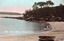 This coloured card shows a sheltered beach with a rowboat and a rocky, tree-covered shoreline: On the card is printed “235. SHELLY BEACH, MANLY, N.S.W Copyright.”