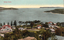 This coloured card shows a harbour entrance with houses and trees in the foreground: On the card is printed “Sydney Heads”.