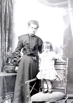 Photo of a woman and a child standing on a chair.