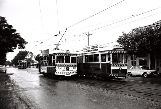 11147.5c Birney car decked out in advertising for the Bendigo Easter Fair heading to North Bendigo in Mcrae St passing No 17 and another tram approaching from the depot