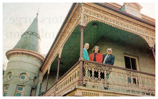 Colour Photo of author Valerie Lovejoy, centre, with Gary Wamest from the Ex-Fortuna Survey Association and City of Greater Bendigo Mayor Barry Ackerman on a verandah at the steps of the grand old mansion.