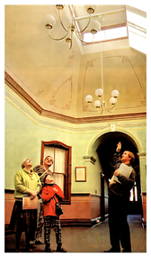 Colour Photo of Fortuna tour guide Mal Fosters pointing out the intricate details of a ceiling in one room, before showing people into one of George Lansell's former dining rooms in the majestic mansion.