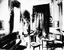 Black and White photo of a music room with piano, chairs and a coffee table