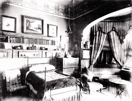 Black and White photo of the family bedroom, with a child's bed and a large four-poseter with curtains
