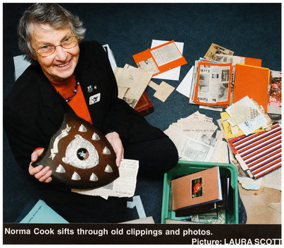 8672.31b Newspaper (Unknown) Article coloured photo of Norma Cook sifting through old clippings and photos, story by Nicole Strahn and photo by Laura Scott.