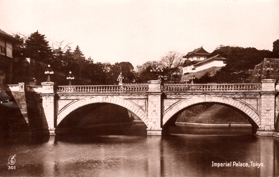 This black-and-white card shows a stone arched bridge across a moat with palace buildings in the background: On the card is printed “301 Imperial Palace, Tokyo.”