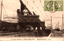 This black-and-white card shows an industrial loading crane beside railway tracks at a port: On the card is printed “A crane belongs to Mitsui Miike Port. The Japanese translates as “Ship-loading crane at Mitsui Miike Port.”