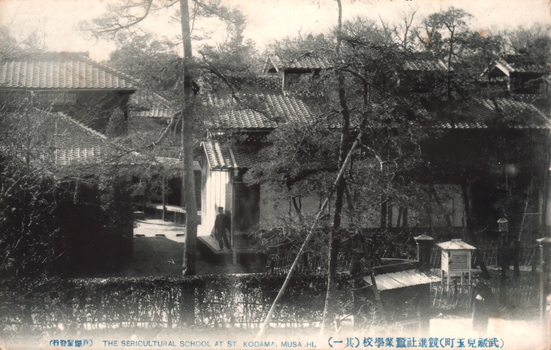This black-and-white card shows traditional school buildings surrounded by trees and gardens: On the card is printed “THE SERICULTURAL SCHOOL AT ST. KODAMA, MUSA-HI. The Japanese translates as “Kyōshinsha Sericultural School, Kodama Town, Musashi (No. 1).” The smaller wording 戸塚堂發行 means “Published by Totsukadō.”