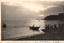 This black-and-white card shows small boats and people silhouetted on calm water beside a shoreline at sunset: On the card is printed “VIEW OF TOMIOKA PORT NISHI-COAST HIGO
The Japanese is printed in the older right-to-left direction:
富岡港西海岸の夕暮 — “Dusk on the western shore of Tomioka Harbour.”
肥後天草 — “Amakusa, Higo.”