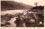 This black-and-white card shows a rocky river flowing through a wooded valley: On the card is printed “商標　VIEW OF SHINKO KOTAN The Japanese is printed mainly in the older right-to-left direction. Read normally:
北海道 — “Hokkaidō.”
壮快ナル神居古譚ノ真景 — “A magnificent true view of Kamui Kotan.”
其四 — “No. 4.”
商標 — “Trademark.”