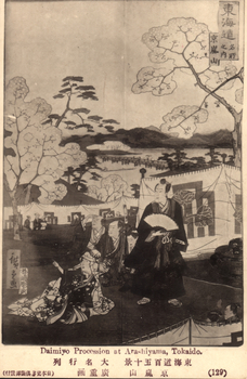 This black-and-white card shows a daimyō procession passing through a decorated outdoor setting at Arashiyama. On the card is printed “東海道名所之内　京嵐山　Daimiyo Procession at Arashiyama, Tokaido.(129)”.
Japanese translation:
東海道名所之内」 — “Among the famous places of the Tōkaidō.”
京嵐山」 — “Arashiyama, Kyoto.”
東海道百五十景」 — “One Hundred and Fifty Views of the Tōkaidō.”
大名行列」 — “Daimyō procession.”
廣重画」 — “Drawn by Hiroshige.”