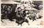 This black-and-white card shows armed men fighting outside a residence in a snowy scene. On the card is printed “The 47 Ronins Attacking Kira’s Residency.” The Japanese is printed from right to left and reads: 義士討入玄關之奮闘」 — “The loyal retainers’ fierce fighting at the entrance during the raid.”