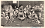 This black-and-white card shows a group of rōnin gathered inside a shop. On the card is printed “47 Ronins Appearing in Full Force at Buckwheat Roll Shop”. The Japanese is printed from right to left and reads: 義士本所蕎麥屋に勢揃をなす」 — “The loyal retainers assemble in full force at a soba shop in Honjo.”
