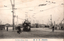 This black-and-white card shows electric trams and pedestrians near a bridge. On the card is printed “The Mansei Bridge, Tokyo”. The Japanese is printed from right to left and reads （東京名所）萬世橋, translating as “Mansei Bridge (a famous place in Tokyo).”