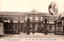 This black-and-white card shows the entrance and façade of a large government building, with an inset portrait of a uniformed military officer. On the card is printed “THE MELITARY DEPARTMENT.” The Japanese is printed right-to-left. Read in modern order, the clearly visible characters are:
（帝都十省）寺内陸軍大臣　陸軍省 The principal wording translates as: “Army Ministry — Army Minister Terauchi.”
陸軍省 — “Army Ministry” or “Ministry of the Army”
寺内陸軍大臣 — “Army Minister Terauchi”
帝都 — “Imperial Capital”