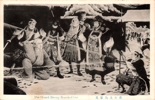 This black-and-white card shows a group of armed Japanese samurai surrounding an older man in a snowy setting. On the card is printed “The Orused Enemy Searched Out” The Japanese is printed right-to-left. Read in modern order, it is: 義士主仇發見 English translation: “The loyal retainers discover their lord’s enemy.”