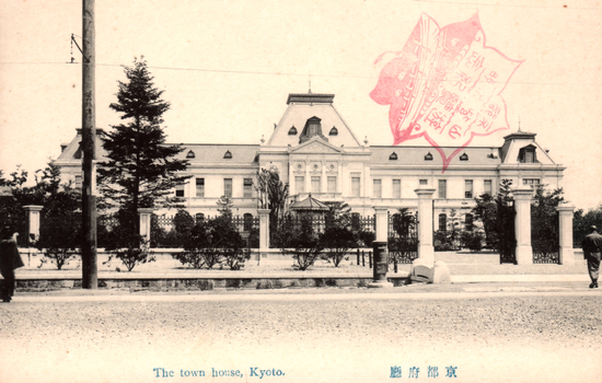 This black-and-white card shows a large civic building behind an ornamental fence and garden. The Japanese 京都府廳 translates as “Kyoto Prefectural Office.” The character 廳 is the older form of the modern 庁.