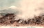This coloured card shows a steaming rocky landscape with Mount Fuji in the distance. On the card is printed “Fuji from Owakidani.” The Japanese translates as “Distant view of Mount Fuji from Ōwakidani.”