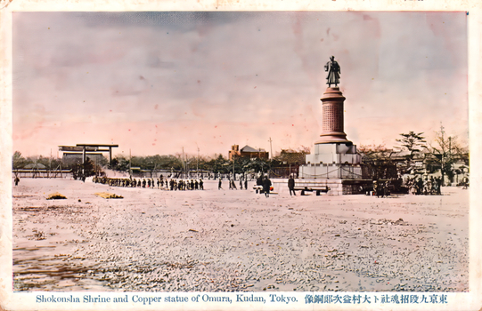 This coloured card shows a shrine precinct with a tall statue on a pedestal and people in the open grounds. On the card is printed “Shokonsba Shrine and Copper statue of Omura, Kudan, Tokyo.” and “東京九段招魂社ト大村益次郎銅像”. The Japanese 東京九段招魂社ト大村益次郎銅像 translates as “Shōkonsha Shrine at Kudan, Tokyo, and the bronze statue of Ōmura Masujirō.”