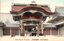 This coloured card shows the entrance gate to a large temple complex with people passing through it. On the card is printed “Gates Higashi Honganji.” and “京都東本願寺（阿彌陀堂門）”. The Japanese translates as “Higashi Honganji, Kyoto (Amida Hall Gate).”