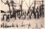 This black-and-white card shows a group of schoolgirls practising in the snow on a wooded slope. On the card is printed “SKATING AT KASHIWASAKI HIGHER GIRLS SCHOOL, NIIGATA” and “新潟縣柏崎高等女學校スキー練習”. The Japanese 新潟縣柏崎高等女學校スキー練習 translates as “Ski practice at Kashiwazaki Higher Girls’ School, Niigata Prefecture.” Notably, the Japanese caption says “ski practice”, although the English caption says “SKATING.”