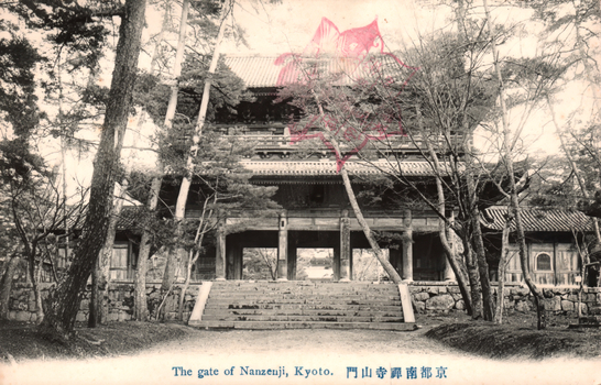 This black-and-white card shows a temple gate at the top of a flight of steps among trees. On the card is printed “The gate of Nanzenji, Kyoto.” and “京都南禪寺山門”. The Japanese translates in English as “The Sanmon gate of Nanzenji, Kyoto.”