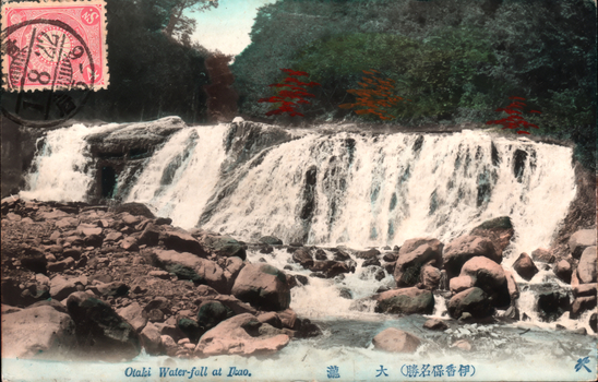 This coloured card shows a waterfall cascading over rocky ledges in a wooded setting. On the card is printed “Otaki Water-fall at Itao.”, “大瀧” and “（伊香保名勝）”. The Japanese translates as:
大瀧 — “Great Waterfall” / “Otaki Waterfall”
伊香保名勝 — “Famous scenic places of Ikaho” / “Ikaho beauty spot”