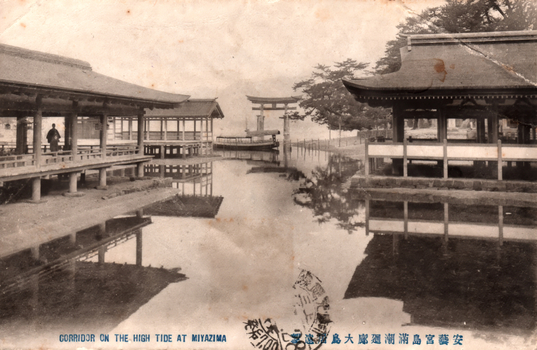 This black-and-white card shows covered corridors and shrine buildings over tidal water, with a torii gate in the distance. On the card is printed “CORRIDOR ON THE. HIGH TIDE AT MIYAZIMA” and “安藝宮島満潮廻廊”. The Japanese translates as:
安藝 — “Aki”
宮島 — “Miyajima”
満潮 — “high tide”
廻廊 — “corridor” / “covered passage”
Together, the Japanese caption means: “Corridor at high tide, Miyajima, Aki.”