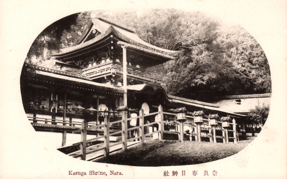 This black-and-white card shows the buildings and lantern-lined approach of Kasuga Shrine. On the card is printed “Kasuga Shrine, Nara.” and “奈良 春日 神社”. Japanese translation:
奈良 — “Nara.”
春日神社 — “Kasuga Shrine.”
Together: “Kasuga Shrine, Nara.”