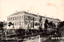 This black-and-white card shows a large two-storey institutional school building surrounded by planted grounds. On the card is printed “The Fourth Higher School” and “第四高等学校”. Japanese translation:
第四 — “Fourth.”
高等学校 — “Higher School.”
第四高等学校 — “The Fourth Higher School.”