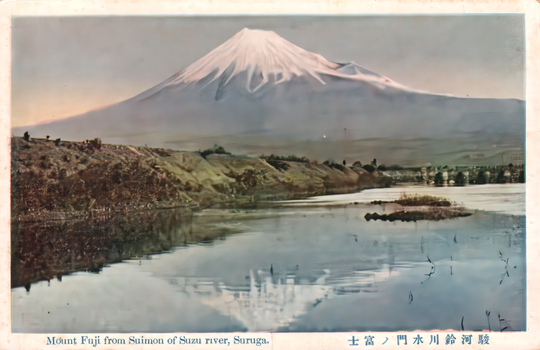 This coloured card shows Mount Fuji beyond a river, with the snow-covered mountain dominating the background. On the card is printed “Mount Fuji from Suimon of Suzu river, Suruga.” and “駿河鈴川水門ノ富士”. Japanese translation: 駿河鈴川水門ノ富士 — “Mount Fuji from the sluice/water gate at Suzukawa, Suruga.” Here ノ is the older katakana form used for the possessive “of/from.”