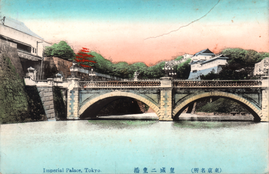 This coloured card shows a large arched bridge over the palace moat, with stone walls and palace buildings beyond. On the card is printed “Imperial Palace, Tokyo.” and “（東京名所）皇城二重橋”. Japanese translation:
（東京名所）皇城二重橋 — “(Famous sight of Tokyo) Nijūbashi Bridge at the Imperial Palace.”
東京名所 — famous sight of Tokyo
皇城 — Imperial Palace / Imperial Castle
二重橋 — Nijūbashi Bridge, literally “double bridge”