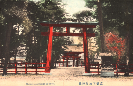 This coloured card shows a large torii and shrine buildings within a wooded shrine precinct at Kyoto. On the card is printed “Shimokamo Shrine at Kyoto.” and “京都下加茂神社”. Japanese translation:
京都下加茂神社 — “Shimokamo Shrine, Kyoto.”
京都 — Kyoto
下加茂神社 — Shimokamo Shrine