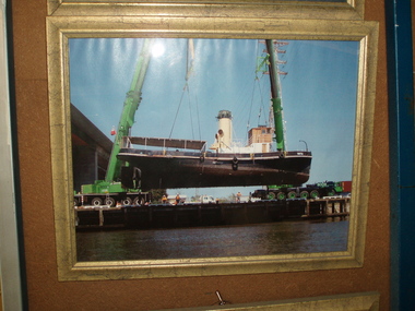 Framed photograph, Ronald Mason, S.T.Wattle being lifted by two cranes from the Yarra River, 10/2009