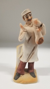 Sculpture - Porcelain figurine of a doctor holding a baby
