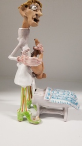 Sculpture - Porcelain figurine of a doctor holding a monkey