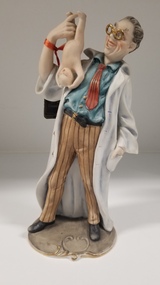 Sculpture - Porcelain figurine of a doctor holding a newborn baby, Pucci
