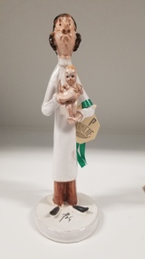 Sculpture - Porcelain figure of a doctor holding a baby
