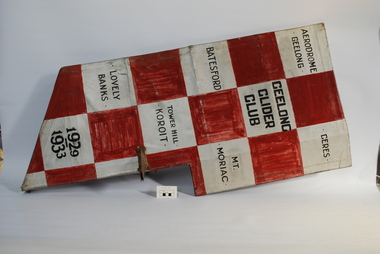 Red and silver checkered object with black lettering