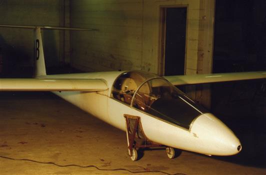 White sailplane in basement workshop