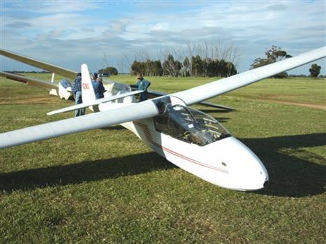 White two seat glider in a grass airfield