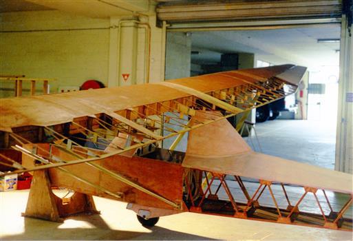 Stripped glider airframe in workshop undergoing repair