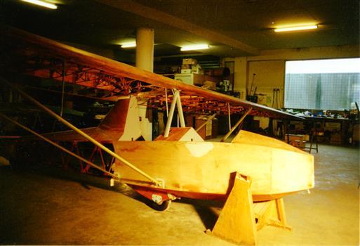 Stripped glider airframe in workshop undergoing repair