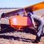Orange glider in field attended by two men