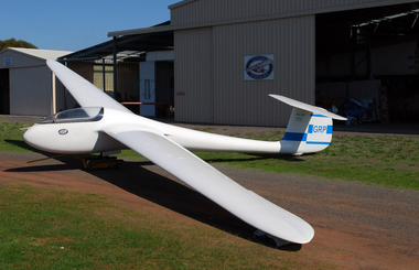 White fibreglass glider in front of hangar