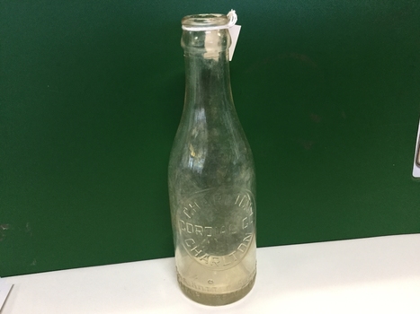 Old Charlton coridal bottle being show or a green background.